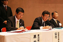 立会人署名を行う山代出雲市議会議長（右）と黒田斐川町議会議長（左）