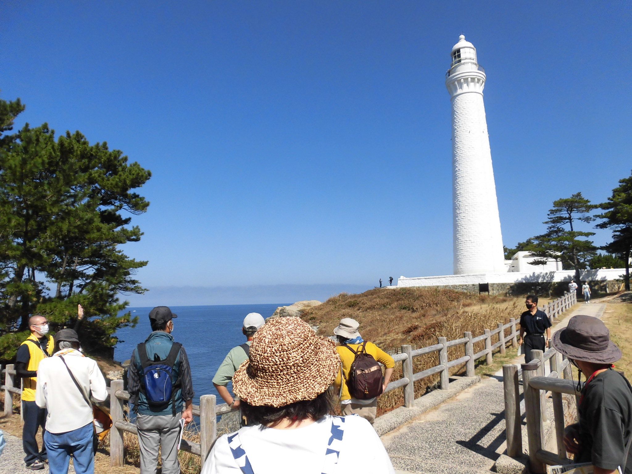 灯台の見える場所で日御碕についての説明を受ける受講者